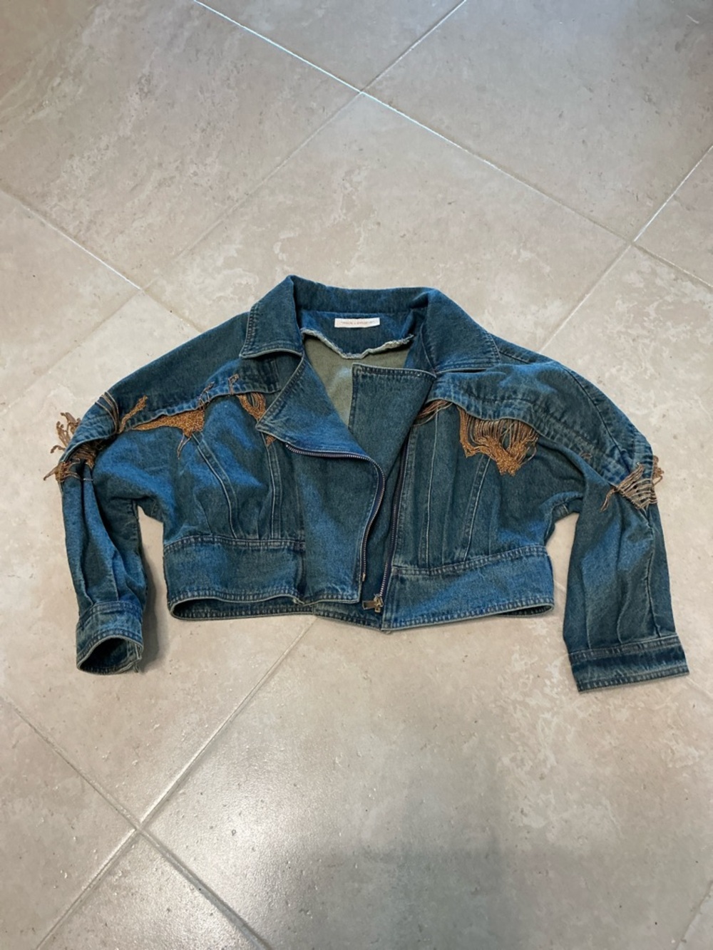 Denim jacket with gold fringe.